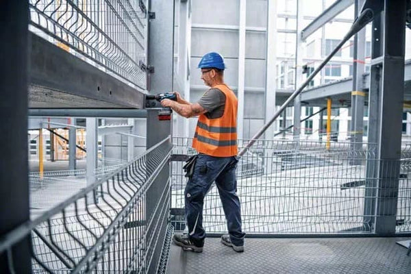Construction worker using Bosch GDS 18V-1050 H Cordless Impact Wrench on site. Power tool fastening bolts.