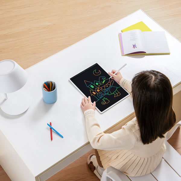 Girl drawing Halloween art on Xiaomi 13.5" LCD color writing tablet. Child sketching on a tablet.