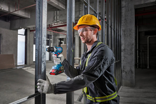 BOSCH PROFESSIONAL CORDLESS IMPACT DRILL GSB 18V-65: Worker using the drill on a construction site.