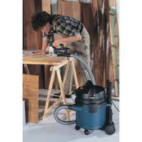 Woodworker using jigsaw with vacuum cleaner, jigsaw blades for wood cutting.